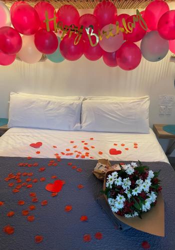 a bed with a bunch of flowers and balloons at CASITA COCO in Playa Grande