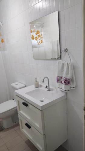 a white bathroom with a sink and a toilet at Aptos em Duas Barras - RJ in Duas Barras