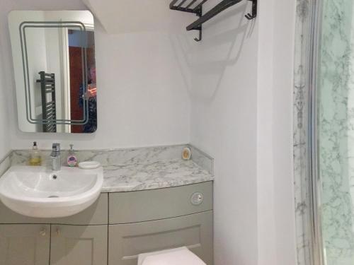 a white bathroom with a sink and a mirror at Ty Newydd in Beddgelert