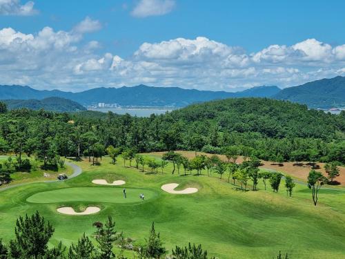 an aerial view of a golf course with mountains in the background at 강진 다산베아채 골프앤리조트 호텔형 in Songhak