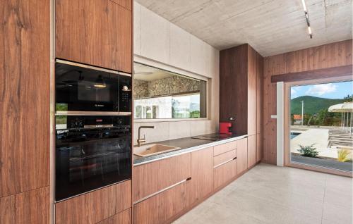 a kitchen with a stove and a sink and a window at Beautiful Home In Dicmo in Dicmo
