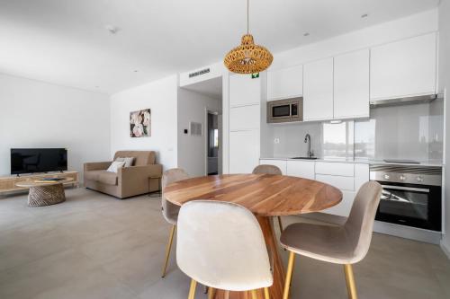 a kitchen and dining room with a wooden table and chairs at Quinta de Bela-Mandil in Olhão