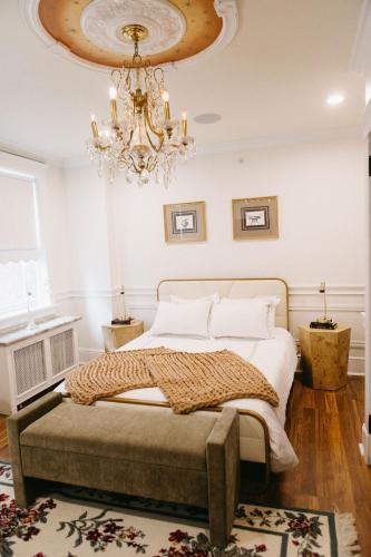 a bedroom with a bed and a chandelier at Chateau Connellsville Eclectic Homage Suite in Connellsville