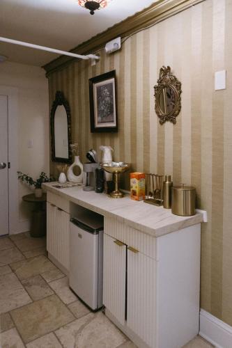 a kitchen with white cabinets and a counter top at Chateau Connellsville Eclectic Homage Suite in Connellsville