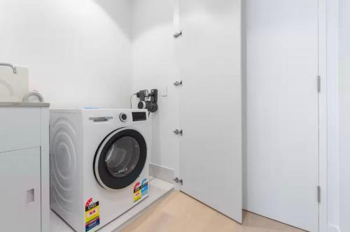 a washer and dryer in a white room at Luxury apartment at Queens Wharf Tower in Brisbane