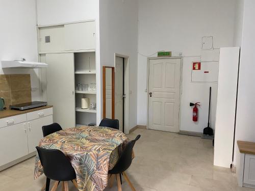 a kitchen with a table and chairs in a room at Guest house D. Filipe I in Porto