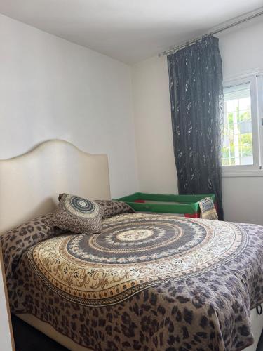 a bedroom with a bed with a patterned blanket on it at Mini Paradise Fnideq in Fnidek