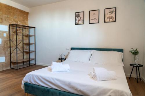 a bedroom with a large white bed with two pillows at Amuri Holiday Home in Agrigento