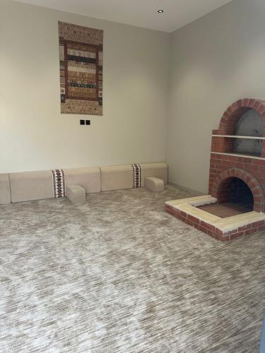 a room with a brick fireplace and a couch at Luma villa in Khamis Mushayt