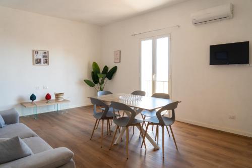 a living room with a table and chairs and a couch at Amuri Holiday Home in Agrigento