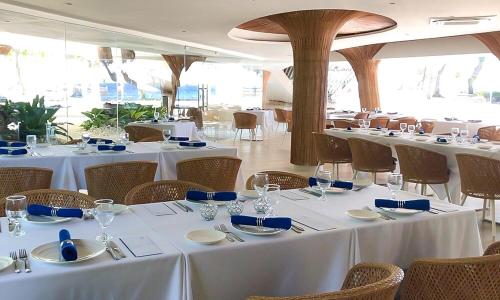 a room with tables and chairs with white tablecloths at 2BR Condo Tambuli Beach Residence in Maribago
