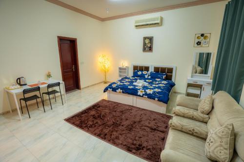 a bedroom with a bed and a table and a couch at Baith al jannah super family friendly rooms in Muşaffaḩ