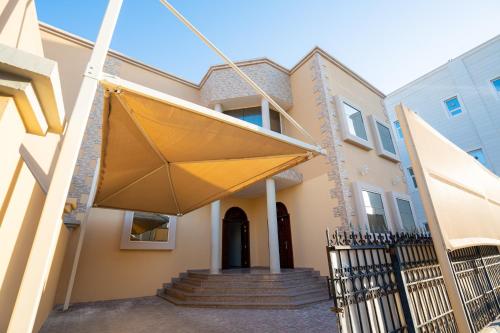 a large yellow umbrella hanging from a house at Baith al jannah super family friendly rooms in Muşaffaḩ