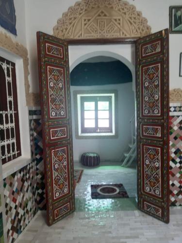 an entrance to a room with a window and a tile floor at Riad Serendipity in Fès
