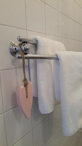 a towel rack with towels and a heart on it at bij Saar in Zwinderen