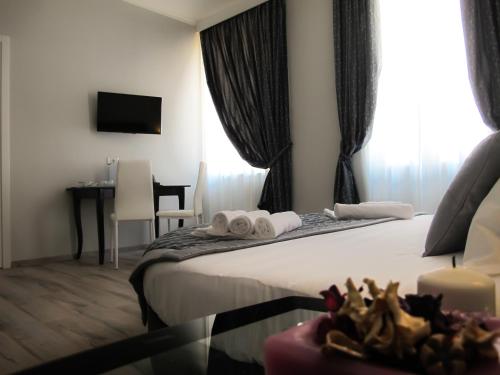 a hotel room with a bed with towels and a table at Roma Veneto Relais in Rome