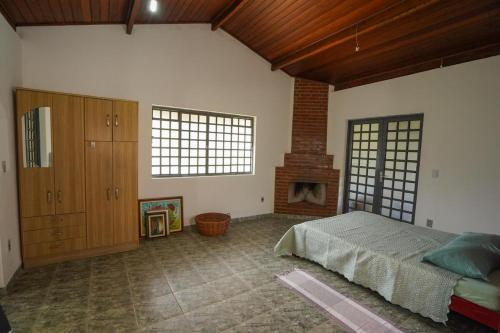 a bedroom with a bed and a fireplace at Chácara Vista Bela in Pinhalzinho