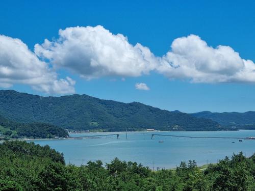 una vista di un lago con le montagne sullo sfondo di Dasan Bearchae Golf N Resort a Kangjin