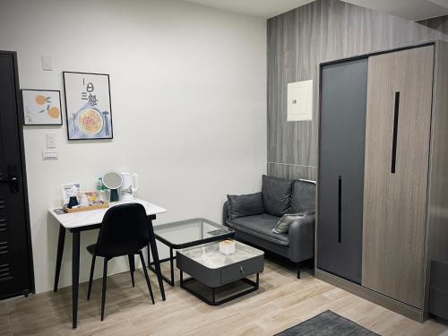 a small living room with a table and a couch at Shigang Homestay市港行旅 in Jinhu