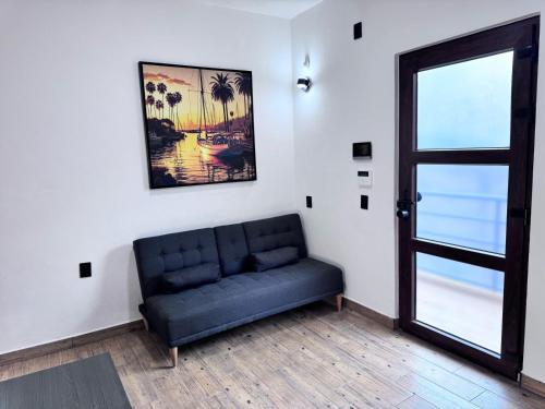 a living room with a blue couch and a window at Casa ZeRo in Manzanillo