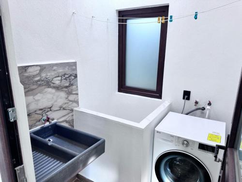 a washing machine in a bathroom with a sink at Casa ZeRo in Manzanillo