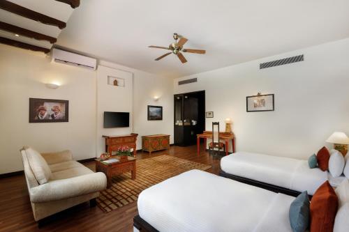 a living room with two beds and a couch at Gokarna Forest Resort Kathmandu in Kathmandu