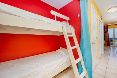 a bunk bed in a room with a red wall at The Dunes 503 condo in Gulf Shores