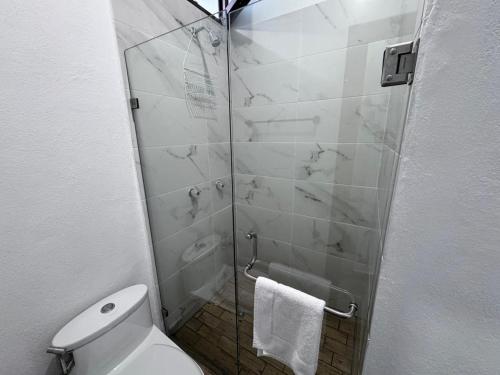 a bathroom with a toilet and a glass shower at Casa ZeRo in Manzanillo