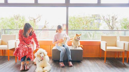 two girls and two dogs sitting in a waiting room at LiVEMAX Resort Izu Kogen Terrace & Spa in Ito