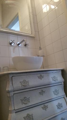 a bathroom with a sink and a dresser at bij Saar in Zwinderen