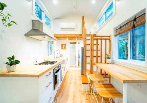 a tiny kitchen with white cabinets and wooden countertops at Riverwood Retreat-hot tub and cedar sauna on the river in Squamish