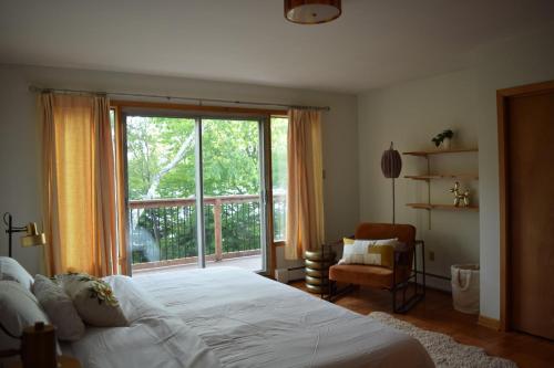 a bedroom with a bed and a large window at Bungalow on Lake Charles Halifax-Dartmouth HRM in Bills Island