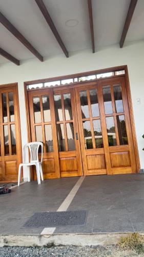 a wooden door with a white chair in front of it at Eco Cabañas Montana in Santa Helena