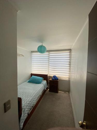 una piccola camera da letto con un letto e una finestra di Teatinos 690 a Santiago