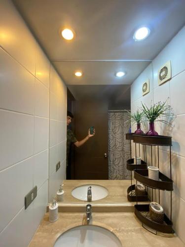 un uomo che scatta una foto allo specchio del bagno di Teatinos 690 a Santiago
