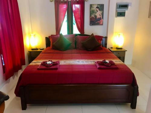 a bedroom with a large red bed with red curtains at Naraya Homestay in San Pa Tong