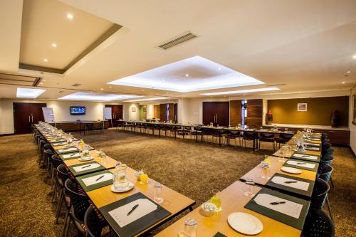 a large room with long tables and chairs at City Lodge Hotel at OR Tambo International Airport in Kempton Park