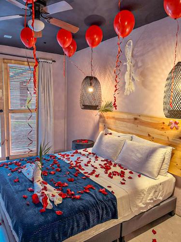 a bedroom with a bed with red roses on it at Hotel Casa de Hadas in Minca
