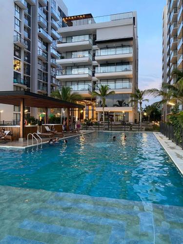 a large swimming pool in front of a building at Excepcional-ApartaSuite-vista al Mar-2 camas in Santa Marta