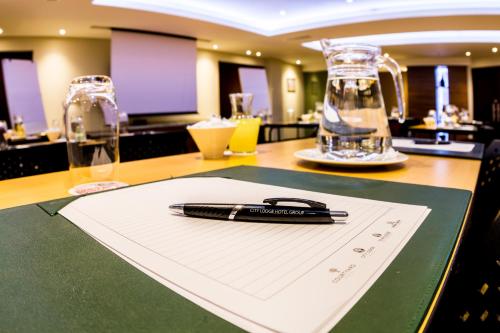 a pen sitting on a piece of paper on a table at City Lodge Hotel at OR Tambo International Airport in Kempton Park
