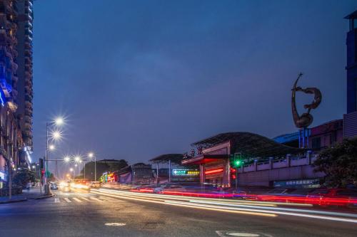 a city street at night with traffic lights and buildings at Chongqing Jiayu Emperor Hotel in Jiulongpo