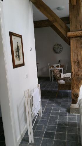 bij Saar في Zwinderen: غرفة معيشة مع أرضية بلاط مع صورة على الحائط