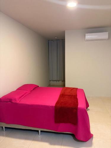 a large pink bed in a white room at Apto de 3 Quartos Vista lateral do Mar a 2km da praia do Araçagy in São Luís