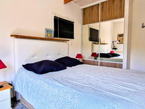 une chambre avec un grand lit avec un grand miroir dans l'établissement Maison F2 indépendante avec terrasse, climatisation et WIFI à Banyuls-sur-Mer - FR-1-309-262, à Banyuls-sur-Mer