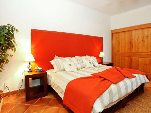 een slaapkamer met een groot bed met een oranje hoofdeinde bij Casa Del Mar Los Cabos in San José del Cabo