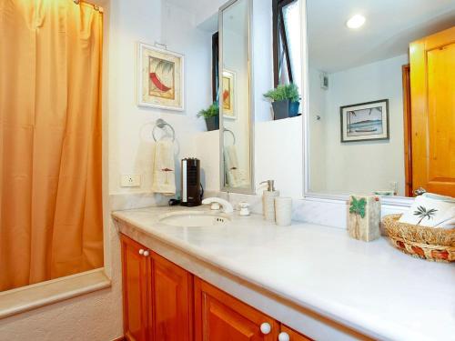 een badkamer met een wastafel en een spiegel bij Casa Del Mar Los Cabos in San José del Cabo