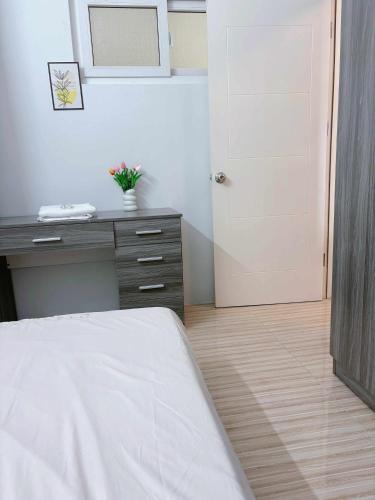 a bedroom with a bed and a desk and a door at An Nam Apartment in Thôn Lại Thê