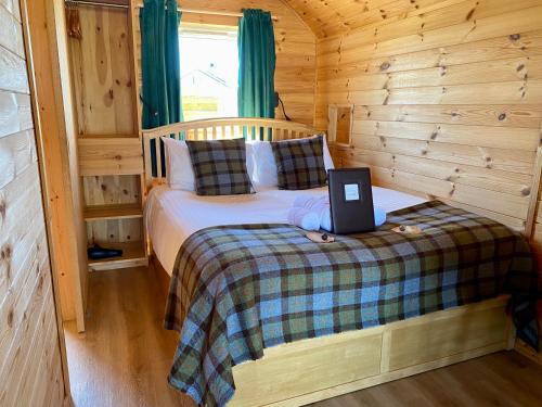 a bedroom with a bed with a laptop on it at SEApods - Isle of Lewis - Luxury en-suite pods on the edge of the Atlantic Ocean in Aird Uig