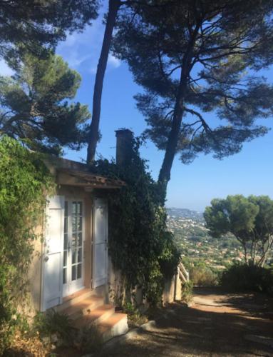 a small white house with trees around it at Petite maison joyau avec vue imprenable sur Canne in Mougins