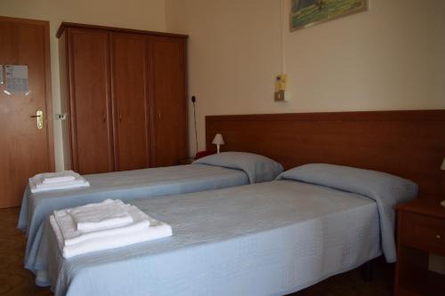 two beds in a hotel room with towels on them at Hotel Astoria in Pesaro